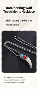 Detail of vintage wolf tooth pendant with silver chain and red blue gemstone accents