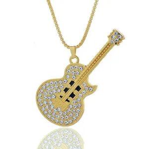 Hip hop style gold guitar pendant necklace with sparkling crystals on white background