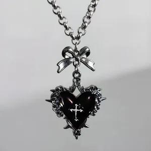 Gothic punk necklace with black heart, silver cross, bow, and rose details on a metal chain