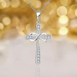 Collier croix infini en argent avec diamants sur fond à effet bokeh chaleureux