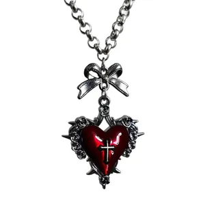 Gothic punk necklace with red heart, silver cross, and metal bow on a heavy chain