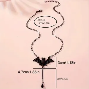 Gothic black bat necklace with red gem pendant on minimalist light pink background