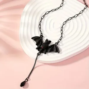Gothic bat necklace with red gemstone and black fringe pendant on white display