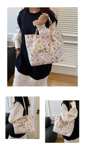Close-up of white tote bag with colorful cartoon prints and plush bunny charm detail