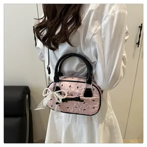 Detail of pink bubble texture bag with black bow accents and pearl lace charm