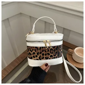 Detail view of leopard print panel box bag featuring double zippers and gold hardware