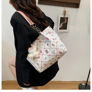 Side view of white tote bag with colorful cartoon prints and pink leather chain strap