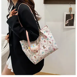 Detail of printed quilted tote bag featuring cartoon bear motifs and pink leather strap