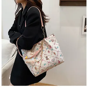 Detail of white tote bag with cute animal prints, pearl chain, and plush bear charm
