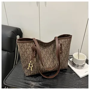 Detail of vintage brown tote bag with DLOU monogram pattern and gold letter R charm