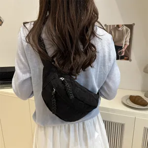 Sac bandoulière noir en velours côtelé avec cordon tissé porté par un modèle