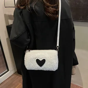 White faux fur cylinder crossbody bag with black heart patch and gold hardware