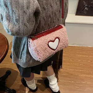 Pink plush cylindrical crossbody bag with white heart and red zipper for women