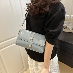Élégant sac bandoulière bleu clair avec fermoir cœur doré porté par un mannequin