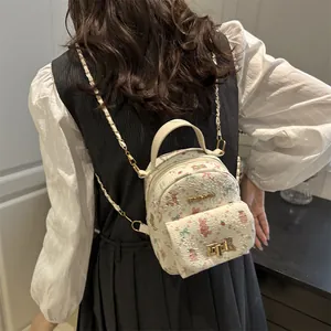 Mini sac à dos blanc avec imprimé lapin et chaîne dorée porté par un modèle