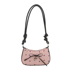 Borsa sottobraccio in seersucker rosa con fiocchi neri e ciondolo a cuore in argento