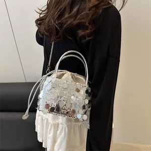 Secchiello chic con paillettes argento e tracolla a catena indossato da modella in set minimal
