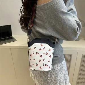 White bucket shoulder bag with red cherry prints and geometric wide strap for women