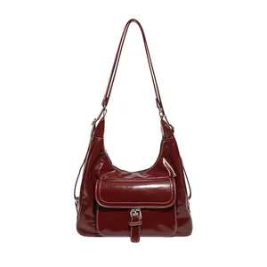 Deep red vintage tote bag with glossy finish and silver buckle front pocket detail
