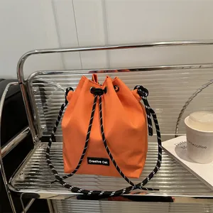 Secchiello arancione vivace con etichetta Creative Cat e tracolla in corda intrecciata