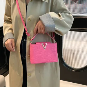 Sac à main carré fuchsia élégant avec logo V argenté et cuir texturé de qualité
