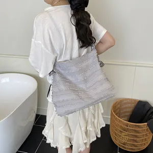 Chic light grey tote bag with layered raw-edge pleats and zebra print shoulder strap