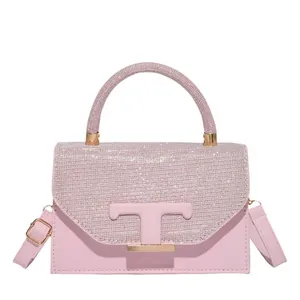 Bolso de mano rosa con pedrería, logotipo T dorado y correa ajustable para mujer