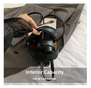 Detail view of mini black backpack interior showing capacity for thermos and lipstick