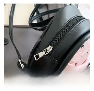 Detailed macro view showing the smooth silver metal zipper and texture of the mini backpack