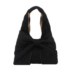 Black quilted tote bag with large bow detail and contrasting camel lining