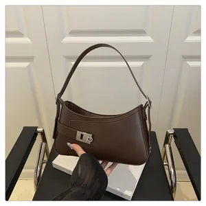 Détail macro du sac hobo asymétrique marron foncé avec finition polie et boucle en métal