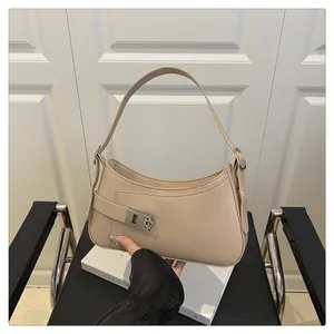 Vue détaillée du sac porté épaule beige avec boucle argentée sur chaise noire