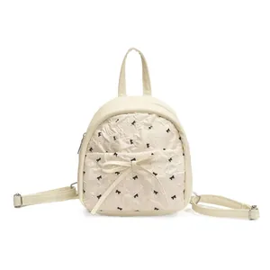 Chic quilted mini backpack in cream with black bow accents and top handle design
