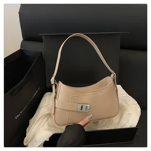 Détail macro du sac demi-lune beige avec boucle argentée et texture en cuir premium