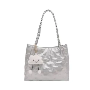 Silver tote bag with embossed bear pattern, braided straps and cloud plush charm