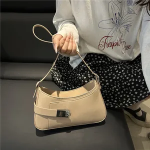 Sac hobo beige minimaliste avec boucle argentée présenté dans un décor lifestyle