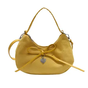 Mustard yellow suede dumpling bag with bow and heart charm for casual street style