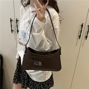 Sac sous le bras minimaliste en cuir marron foncé mat avec boucle argentée sur modèle