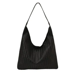 Minimalist black woven hobo shoulder bag with textured leather and sleek crescent shape