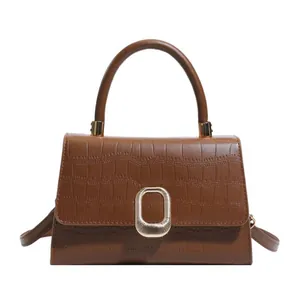 Brown crocodile-textured baguette bag with metal buckle and adjustable shoulder strap