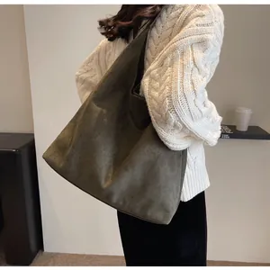 Detailed view of dark olive suede tote bag showing soft texture and large capacity