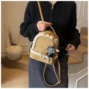 Detail eines khakifarbenen Plüsch-Rucksacks mit Pelzbesatz und Kaninchen-Anhänger