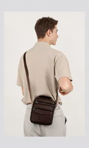 Detailansicht der Rückseite einer braunen Herren-Umhängetasche aus Leder mit Reißverschlüssen