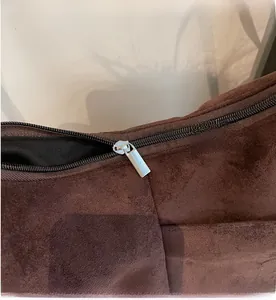 Détail de la fermeture éclair argentée sur le sac en daim café foncé avec doublure
