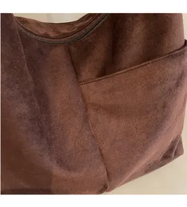 Détail du sac cabas en daim marron foncé avec poche latérale et fermeture éclair métallique