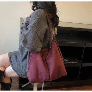 Vue détaillée du grand sac cabas bordeaux en daim avec poche latérale et fermeture éclair