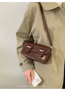 Detail van donkerbruine retro vierkante schoudertas met dubbele gespkleppen