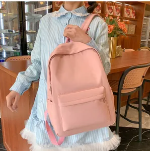 Detail eines hellrosa Freizeitrucksacks mit mehreren Taschen und glattem Nylongewebe