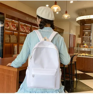 Rückansicht eines weißen minimalistischen Rucksacks mit Vordertasche in einer Bäckerei