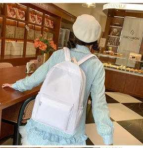 Nahaufnahme des weißen minimalistischen Canvas-Rucksacks mit Reißverschlusstasche im Café